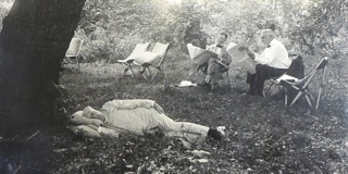 Thomas Edison takes a nap while Harvey Firestone and President Warren Harding read the newspaper.  Henry Ford, Harvey Firestone, Thomas Edison and President Harding, (who arrived in a Packard, not a Ford), motored to the Firestone estate in Maryland for an afternoon of relaxation. The National Photo Company went along and made this photograph.  The National Photo Company was a  major player in Washington news pictures in 1921. On June 13, 1921, twenty-four movie and still men met in the offices of the National Photo Company and formed the White House News Photographers Association.