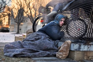 Nicholas Simmons, 20, of Greece, N.Y., warms himself on a steam grate with three homeless men by the Federal Trade Commission, just blocks from the Capitol, during frigid temperatures in Washington, Saturday, Jan. 4, 2014. (Photograph by Jacquelyn Martin/Associated Press)